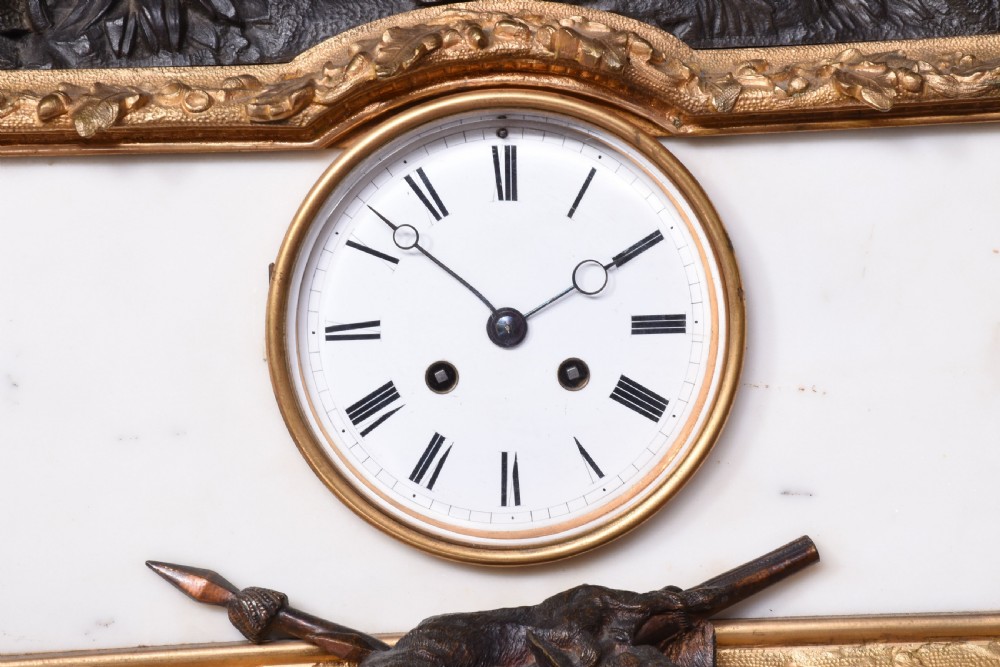 A three-piece French Napoleon III clock garniture featuring a central white marble clock topped with a bronze equestrian hunting sculpture, flanked by a pair of matching bronzed and gilt candelabra. View V