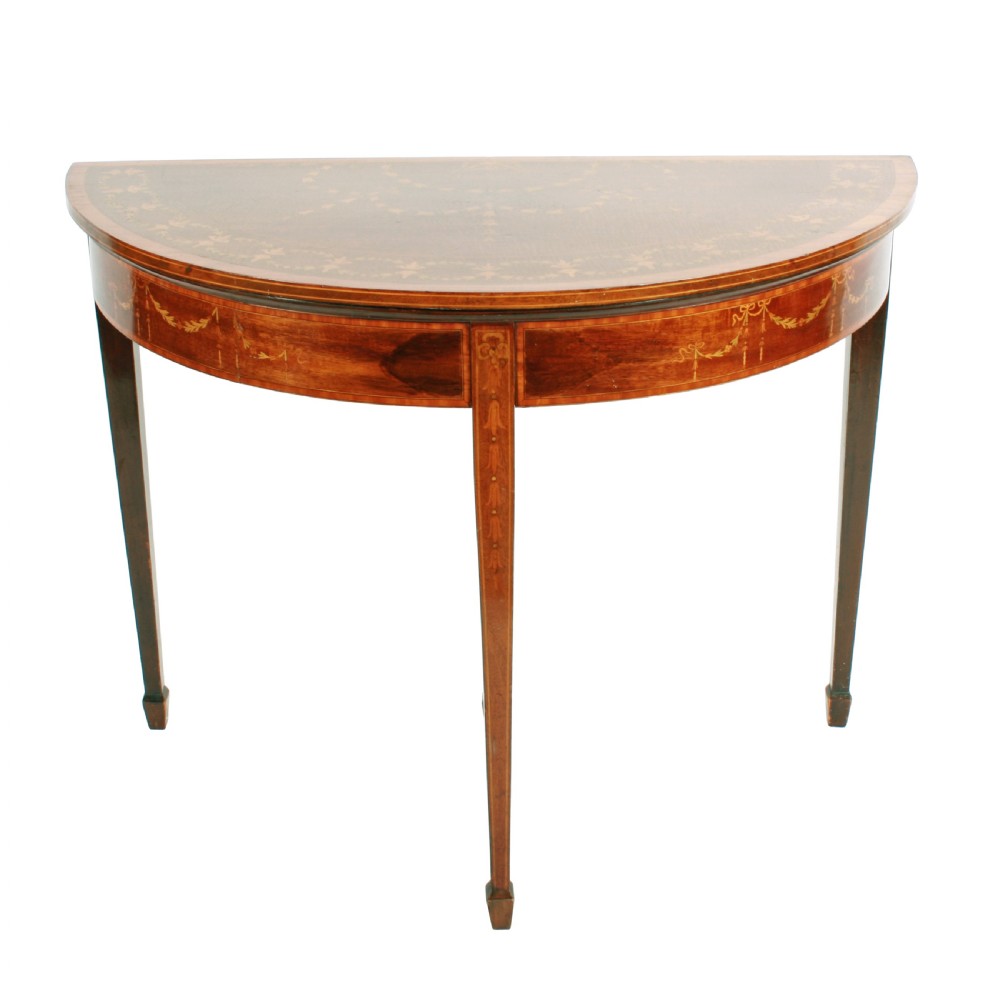 A semi-circular mahogany card table featuring floral marquetry inlay on the top and apron, supported by four square tapered legs. View III
