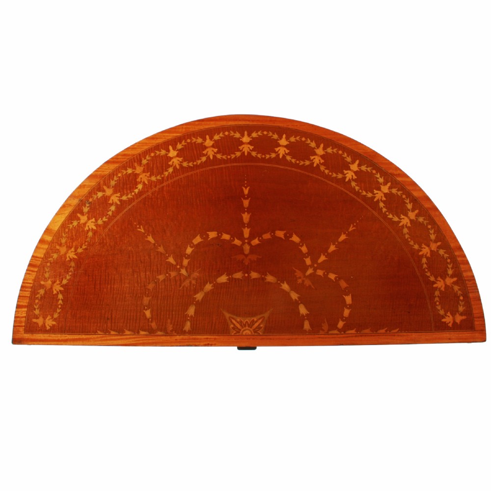 A semi-circular mahogany card table featuring floral marquetry inlay on the top and apron, supported by four square tapered legs. View IV