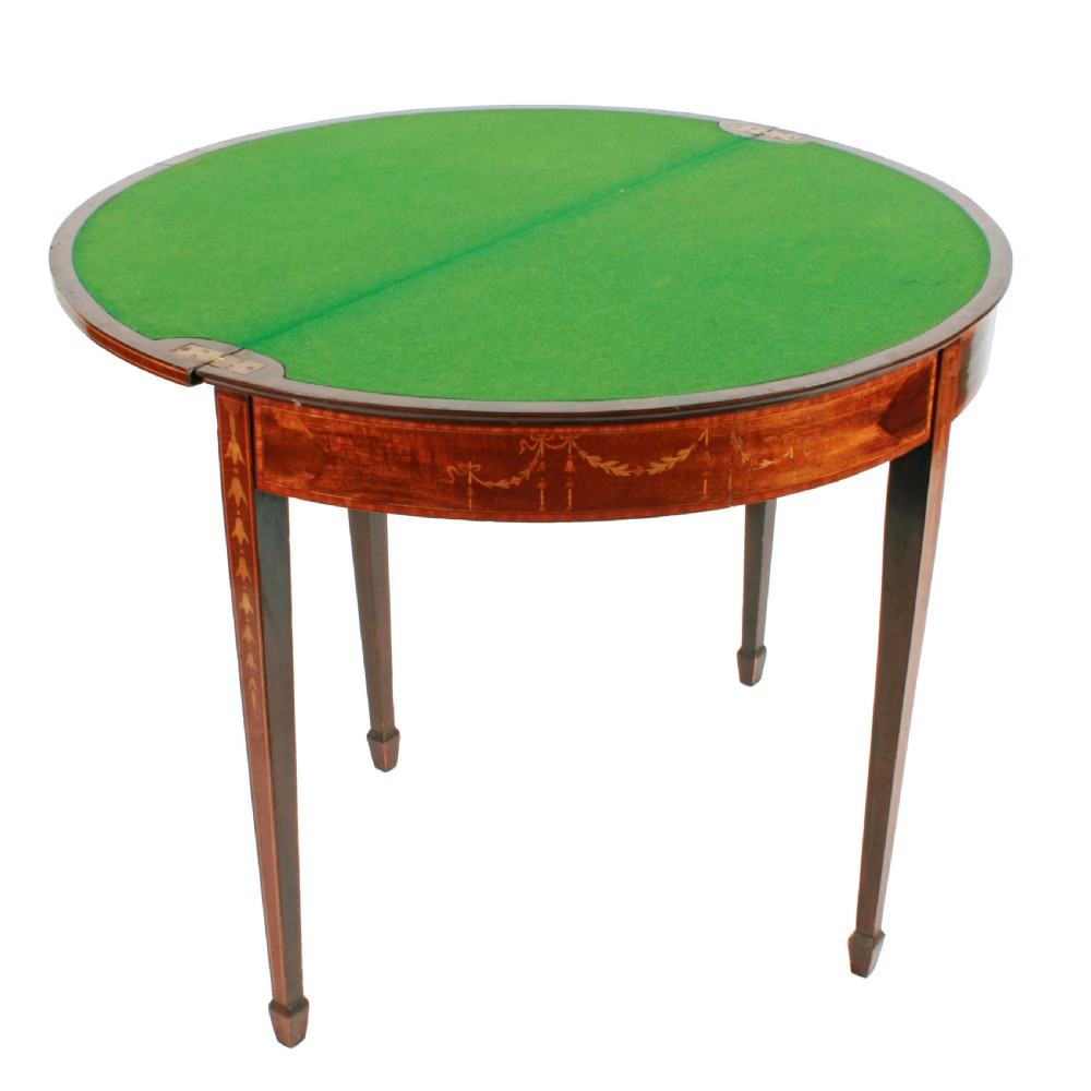 A semi-circular mahogany card table featuring floral marquetry inlay on the top and apron, supported by four square tapered legs. View V