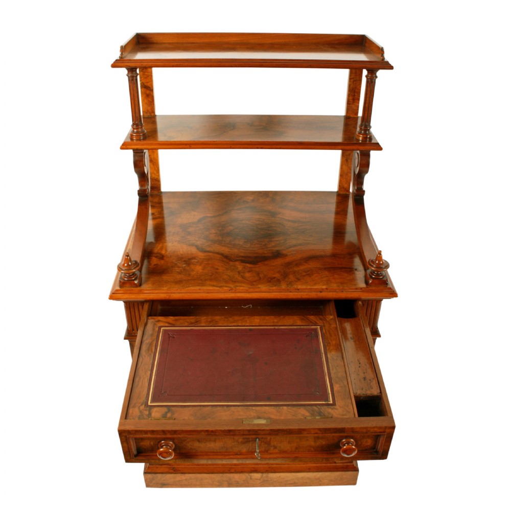 A mid-Victorian burr walnut writing desk featuring an upper superstructure with two open shelves supported by turned columns and scrolled side brackets above four drawers with turned wooden knobs. View V