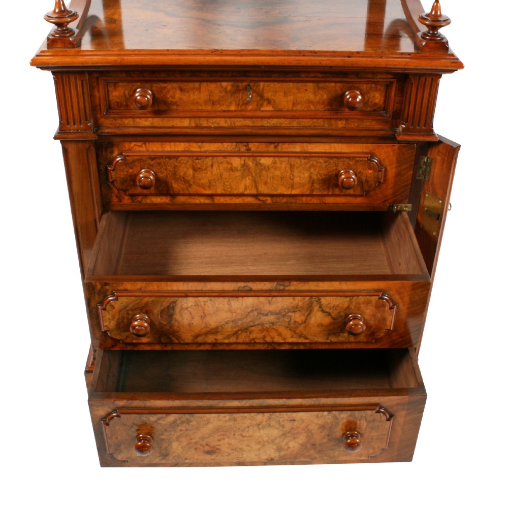 A mid-Victorian burr walnut writing desk featuring an upper superstructure with two open shelves supported by turned columns and scrolled side brackets above four drawers with turned wooden knobs. View VI