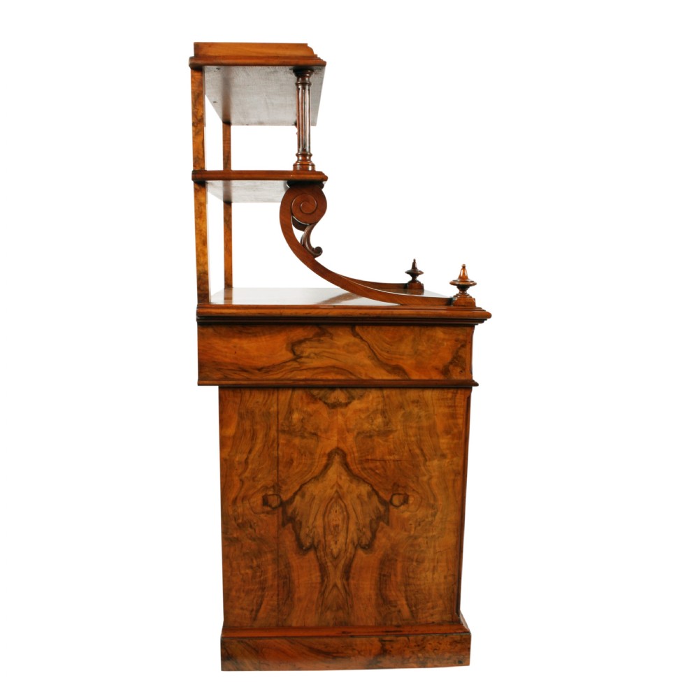 A mid-Victorian burr walnut writing desk featuring an upper superstructure with two open shelves supported by turned columns and scrolled side brackets above four drawers with turned wooden knobs. View VII