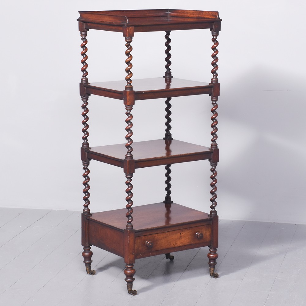 An early Victorian four-tier mahogany whatnot featuring barley twist supports, a gallery top, a single base drawer, and turned legs on brass castors.