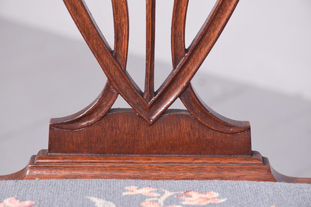 A set of eight Edwardian mahogany dining chairs in the Hepplewhite style featuring carved shield backs and pale blue upholstered seats. View III