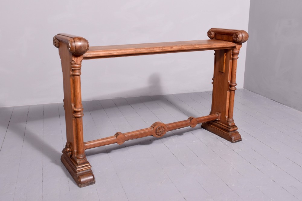 A narrow pitch pine console table featuring a rectangular top, turned twin-column end supports, and a central stretcher with a carved rosette motif. View VII