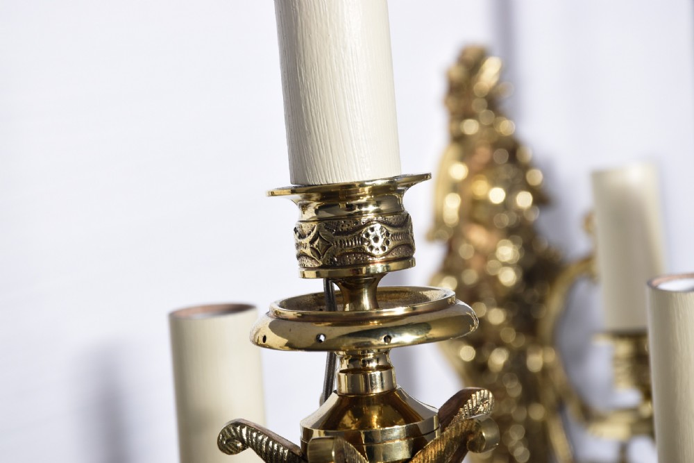 A pair of cast brass Rococo-style five-light wall sconces featuring scrollwork backplates and sweeping candle arms. View VIII