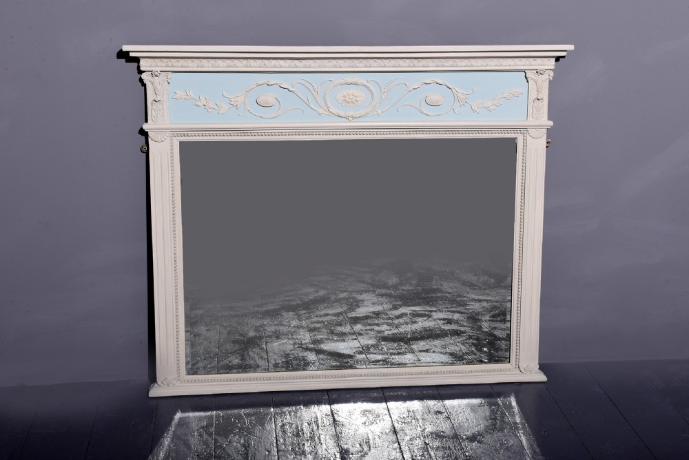 A Neoclassical painted overmantel mirror with an off-white fluted frame, beaded trim, and a light blue frieze featuring plaster swags and floral medallion details. View II