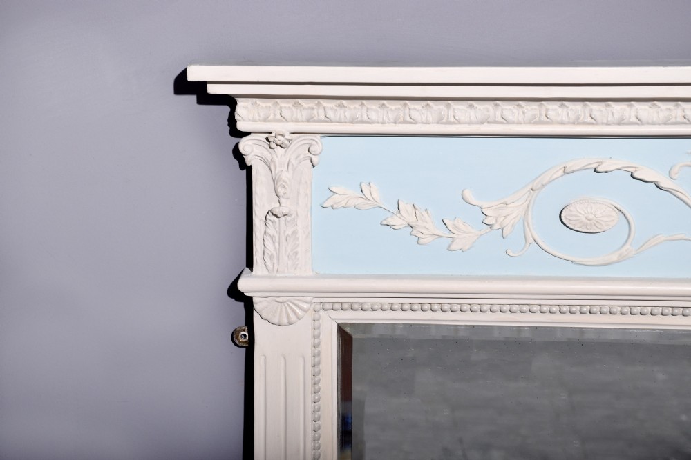 A Neoclassical painted overmantel mirror with an off-white fluted frame, beaded trim, and a light blue frieze featuring plaster swags and floral medallion details. View IV