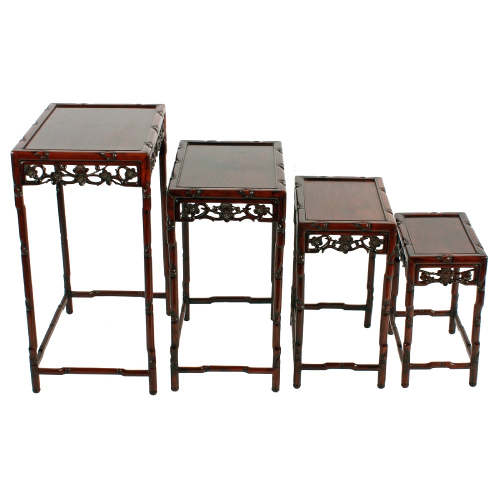 A set of four graduated dark brown Chinese hardwood nesting tables featuring faux-bamboo carved legs and pierced openwork aprons. View II
