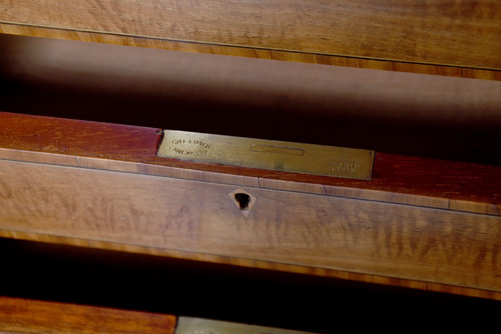 A satinwood Carlton House writing desk featuring a brass gallery railing, U-shaped superstructure with small drawers, leather writing surface, and square tapered legs on castors. View VII