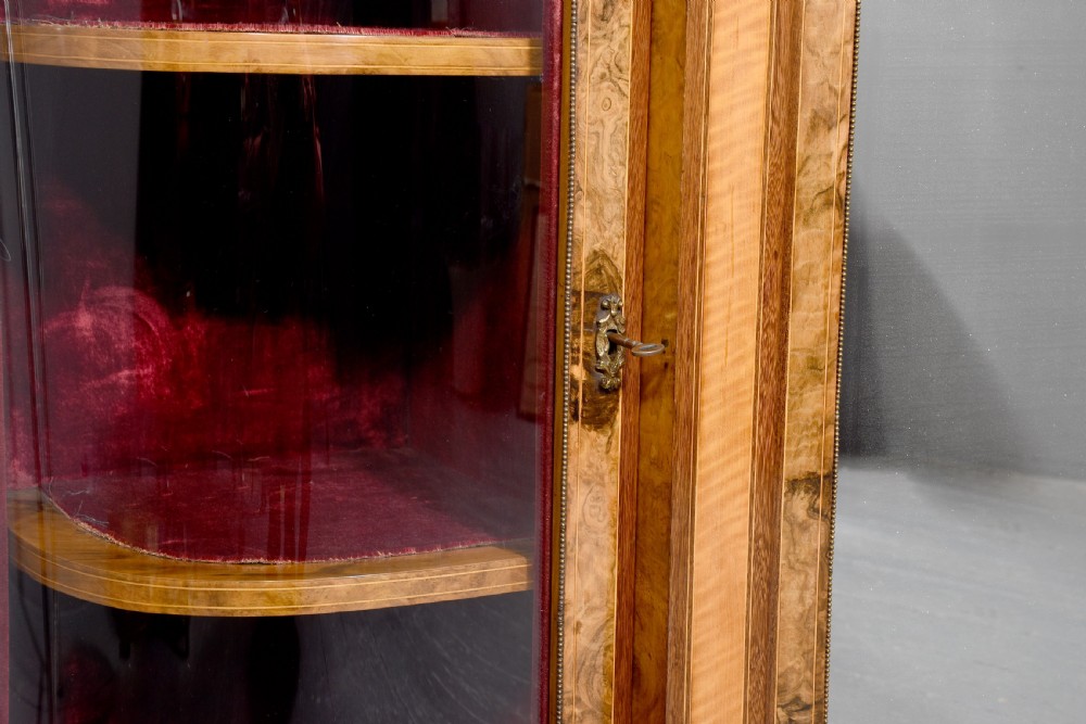 A Mid-Victorian burr walnut and satinwood credenza with mirrored central doors, curved glass side cupboards, and gilt ormolu mounts. View XII