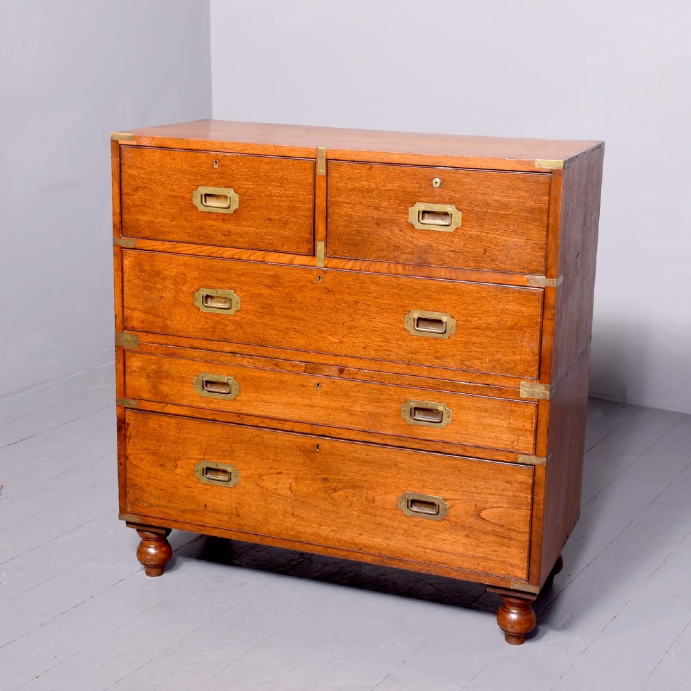 A Victorian mahogany two-part military campaign chest with flush brass handles, protective brass corner brackets, and turned legs.