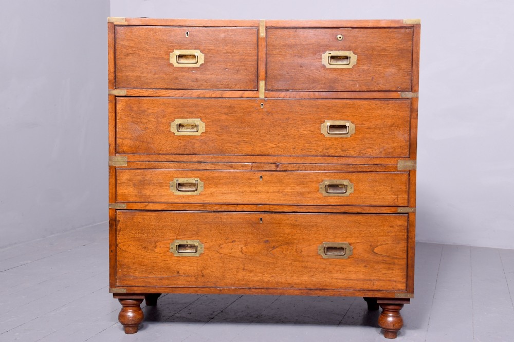 A Victorian mahogany two-part military campaign chest with flush brass handles, protective brass corner brackets, and turned legs. View V