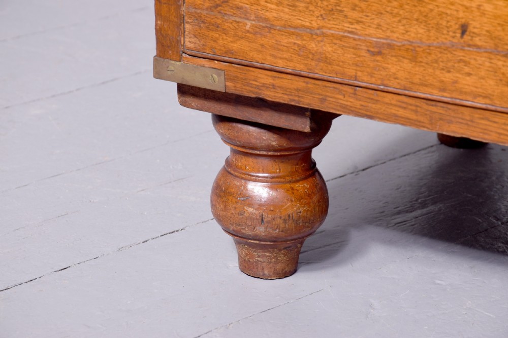 A Victorian mahogany two-part military campaign chest with flush brass handles, protective brass corner brackets, and turned legs. View VII