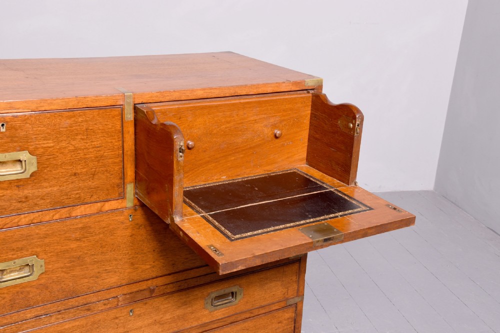 A Victorian mahogany two-part military campaign chest with flush brass handles, protective brass corner brackets, and turned legs. View IX