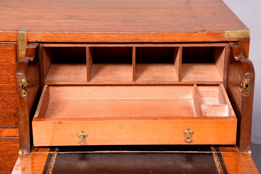 A Victorian mahogany two-part military campaign chest with flush brass handles, protective brass corner brackets, and turned legs. View X