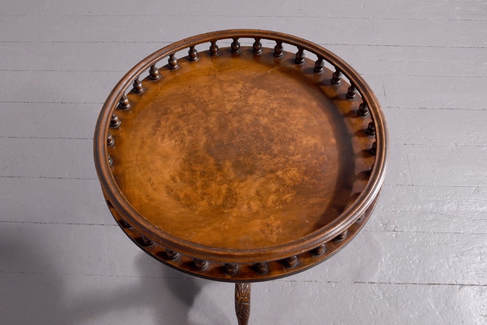 A round mahogany occasional table featuring a raised spindle gallery top, turned central pedestal stem, and cabriole tripod legs ending in claw and ball feet. View II