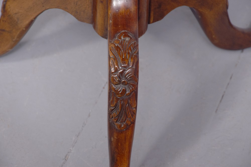 A round mahogany occasional table featuring a raised spindle gallery top, turned central pedestal stem, and cabriole tripod legs ending in claw and ball feet. View IV