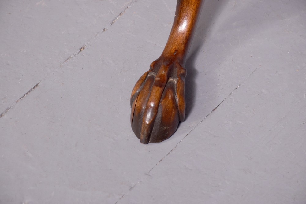 A round mahogany occasional table featuring a raised spindle gallery top, turned central pedestal stem, and cabriole tripod legs ending in claw and ball feet. View VI
