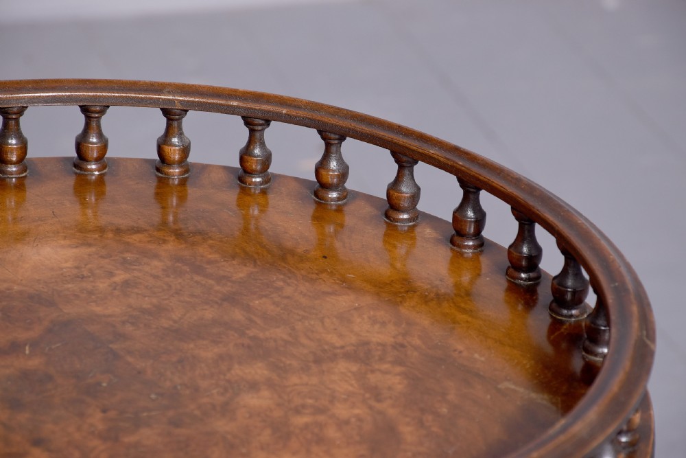 A round mahogany occasional table featuring a raised spindle gallery top, turned central pedestal stem, and cabriole tripod legs ending in claw and ball feet. View VII