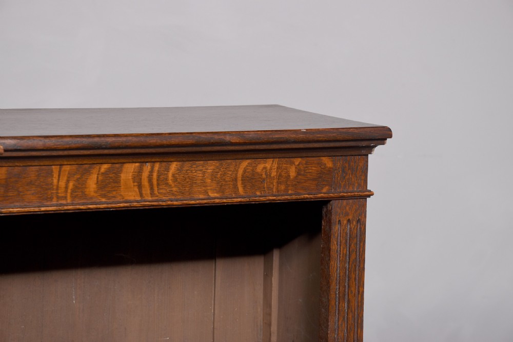 A large dark oak breakfront open bookcase filled with rows of leather-bound books. View VII