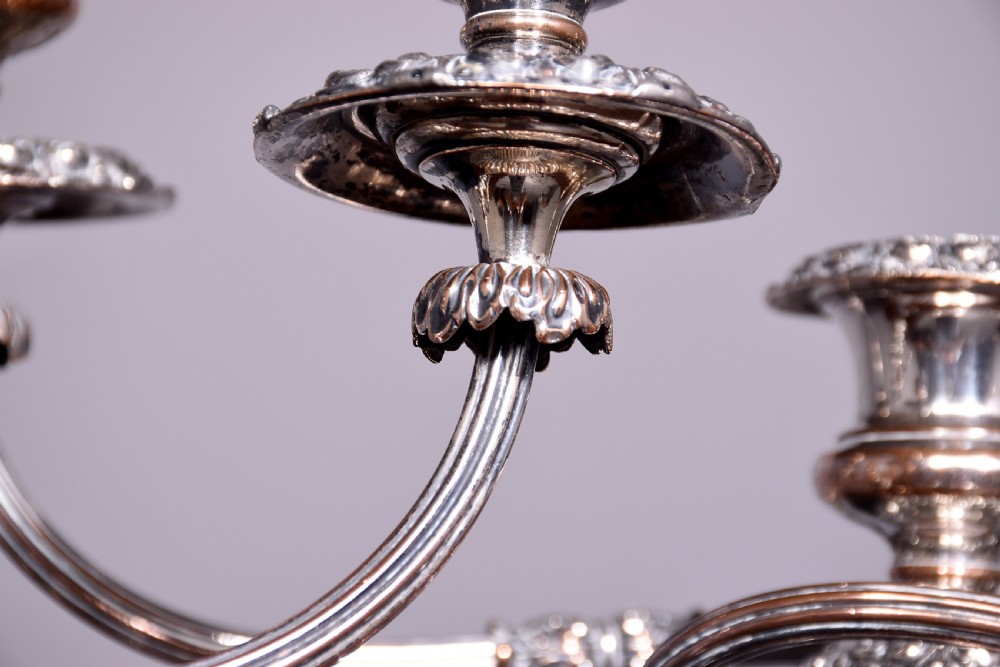 A pair of antique silver-plated three-light candelabra featuring circular bases, baluster stems, and curved reeded branches. View VI