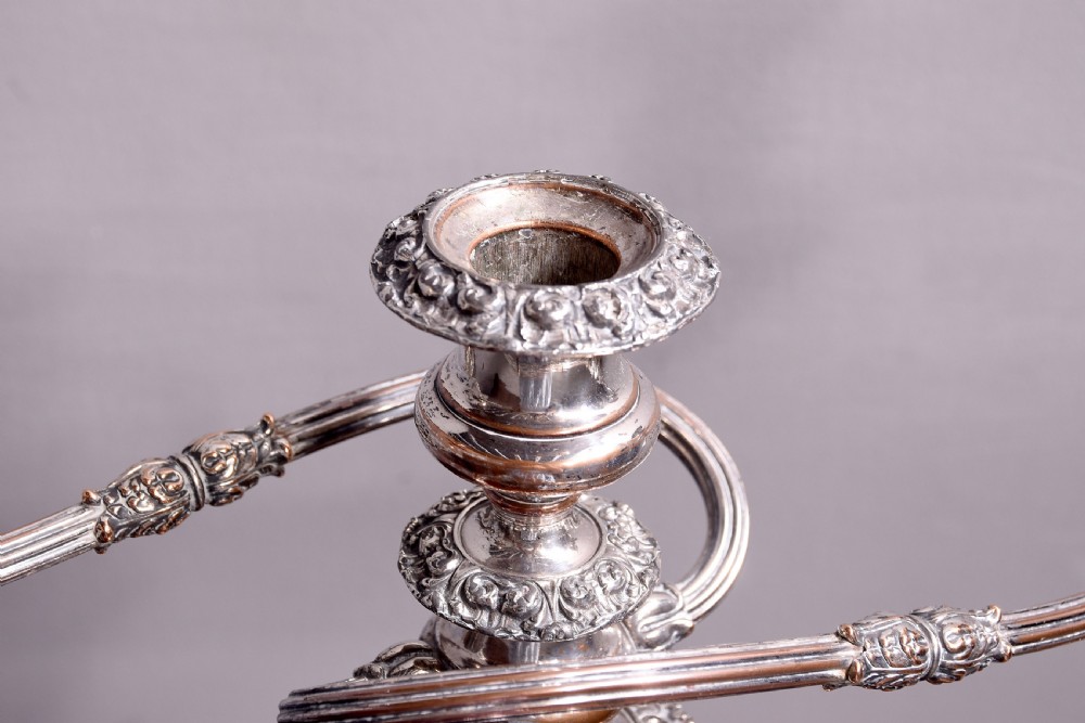 A pair of antique silver-plated three-light candelabra featuring circular bases, baluster stems, and curved reeded branches. View IX