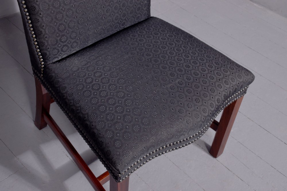 A set of four George III style side chairs upholstered in dark grey patterned fabric with brass stud trimming and straight mahogany legs. View III