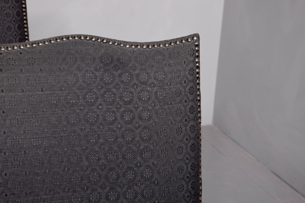 A set of four George III style side chairs upholstered in dark grey patterned fabric with brass stud trimming and straight mahogany legs. View V