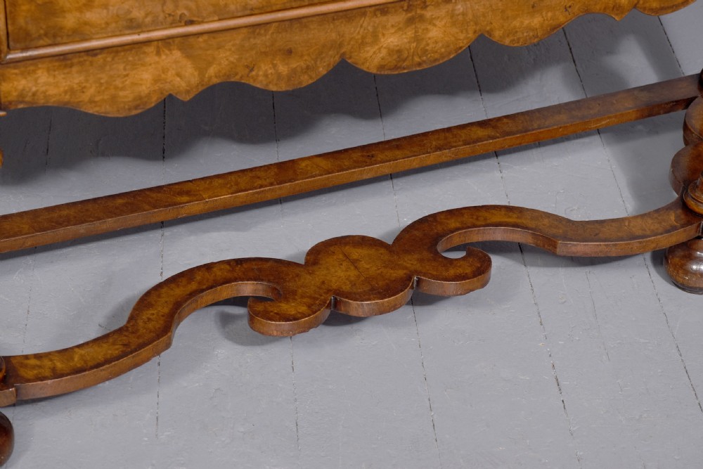 A nineteenth-century Dutch burr walnut display cabinet featuring canted glazed sides, an arched cresting cornice, two lower drawers, and turned legs connected by a shaped stretcher. View VI