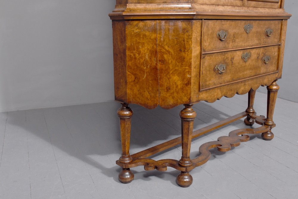 A nineteenth-century Dutch burr walnut display cabinet featuring canted glazed sides, an arched cresting cornice, two lower drawers, and turned legs connected by a shaped stretcher. View VII