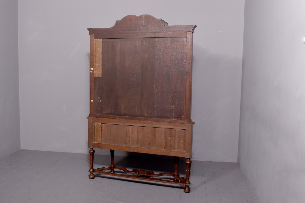 A nineteenth-century Dutch burr walnut display cabinet featuring canted glazed sides, an arched cresting cornice, two lower drawers, and turned legs connected by a shaped stretcher. View XV