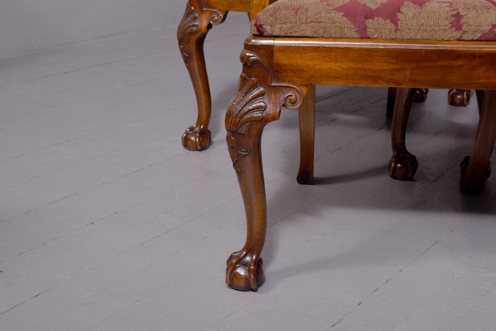 A set of George II style carved walnut dining chairs featuring pierced back splats, cabriole legs with claw and ball feet, and patterned upholstered seats. View II