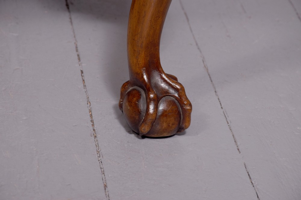A set of George II style carved walnut dining chairs featuring pierced back splats, cabriole legs with claw and ball feet, and patterned upholstered seats. View III