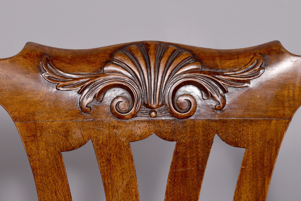 A set of George II style carved walnut dining chairs featuring pierced back splats, cabriole legs with claw and ball feet, and patterned upholstered seats. View IV