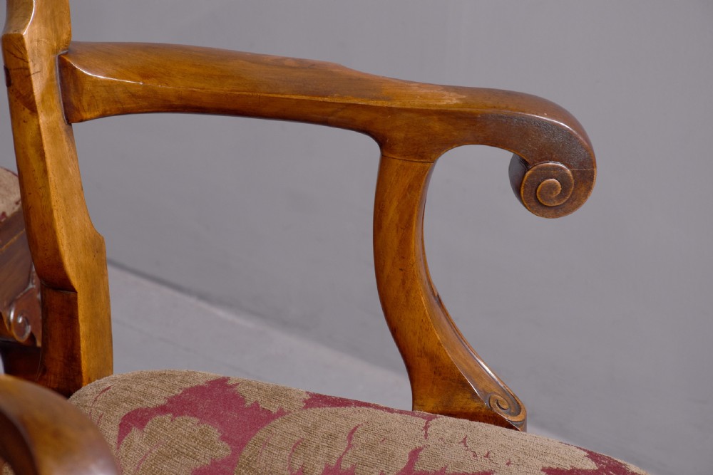 A set of George II style carved walnut dining chairs featuring pierced back splats, cabriole legs with claw and ball feet, and patterned upholstered seats. View V