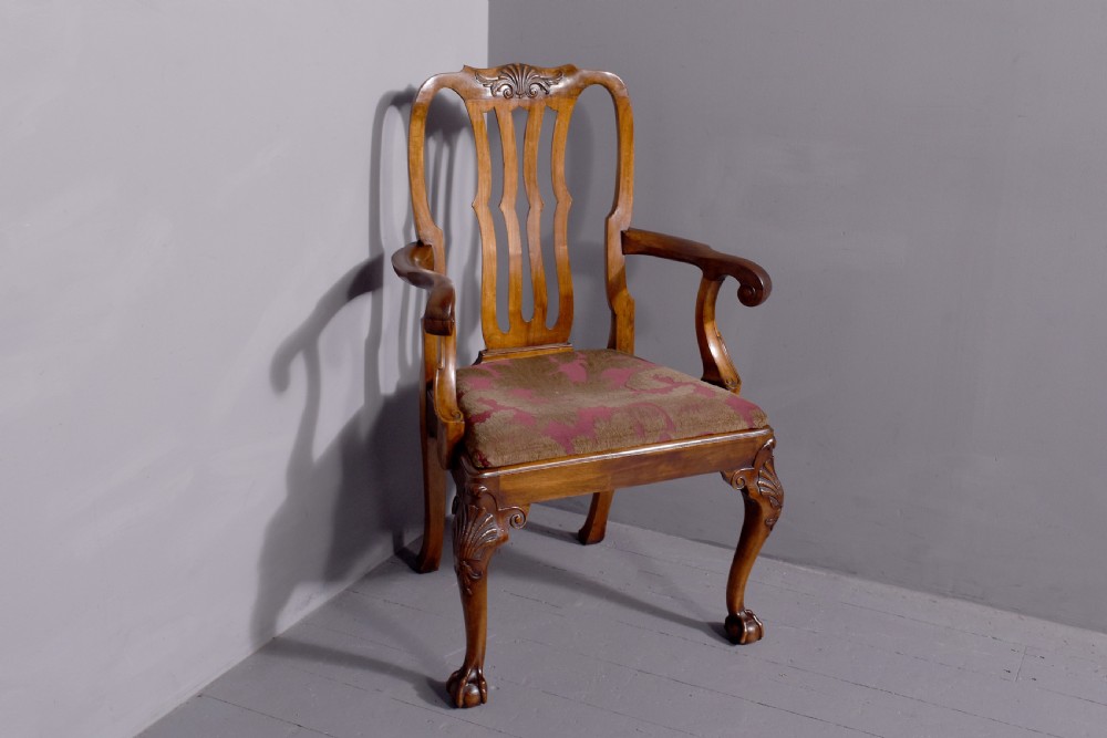 A set of George II style carved walnut dining chairs featuring pierced back splats, cabriole legs with claw and ball feet, and patterned upholstered seats. View IX