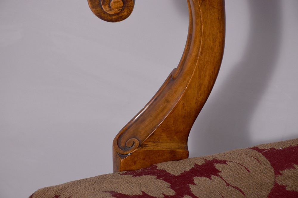 A set of George II style carved walnut dining chairs featuring pierced back splats, cabriole legs with claw and ball feet, and patterned upholstered seats. View X
