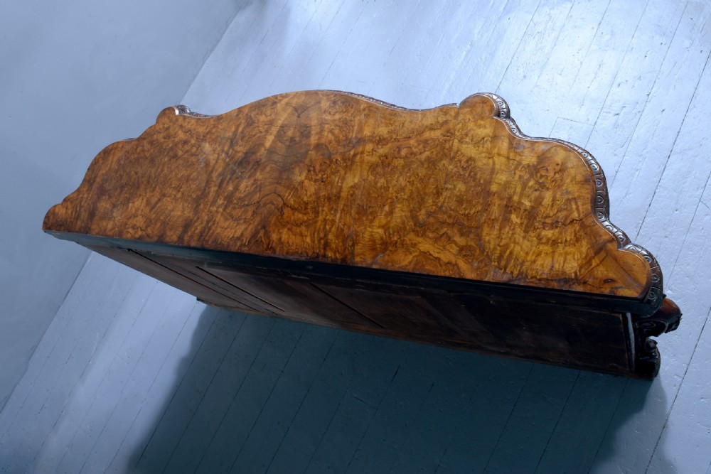 A mid-Victorian burr walnut serpentine-fronted credenza featuring carved female figure pilasters, central mirrored doors, and curved glass side display cabinets. View IX