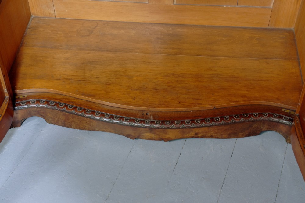 A mid-Victorian burr walnut serpentine-fronted credenza featuring carved female figure pilasters, central mirrored doors, and curved glass side display cabinets. View XII