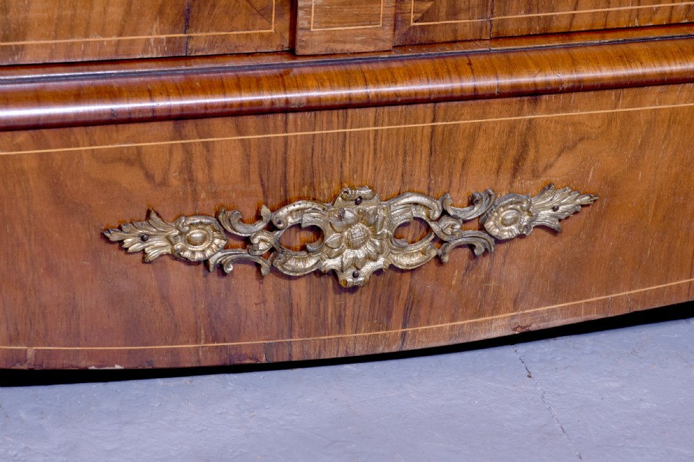 A Victorian figured walnut cabinet featuring twin glazed doors, intricate marquetry floral inlay along the frieze, gilt bronze mounts, and a red fabric-lined interior with three shelves. View III