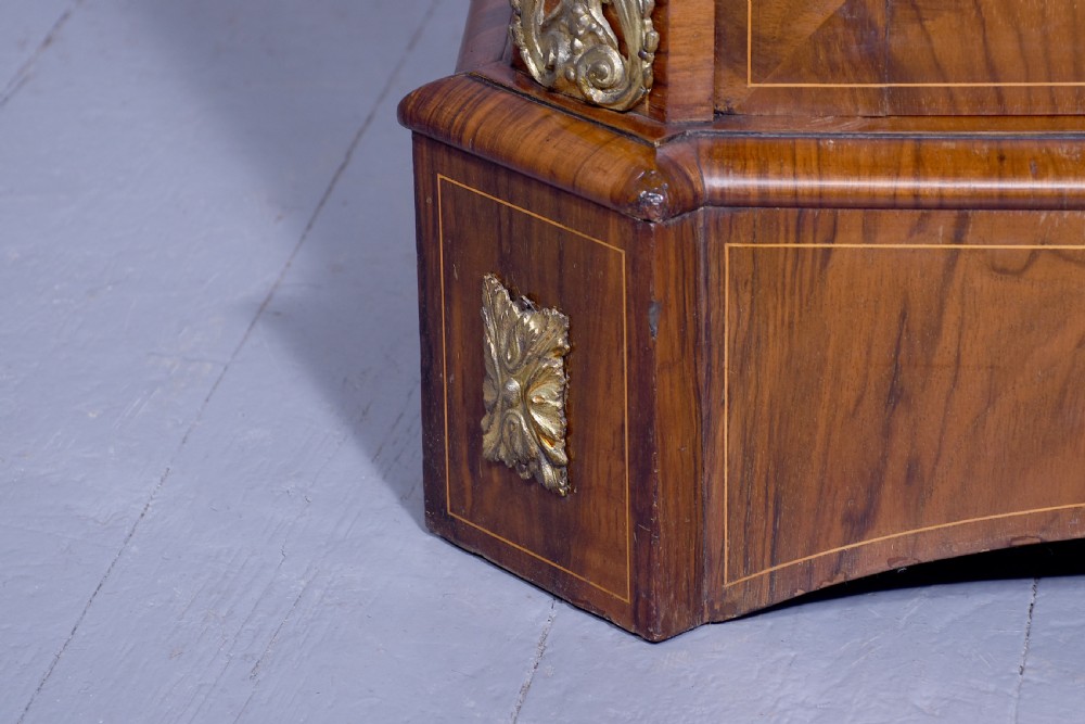 A Victorian figured walnut cabinet featuring twin glazed doors, intricate marquetry floral inlay along the frieze, gilt bronze mounts, and a red fabric-lined interior with three shelves. View V