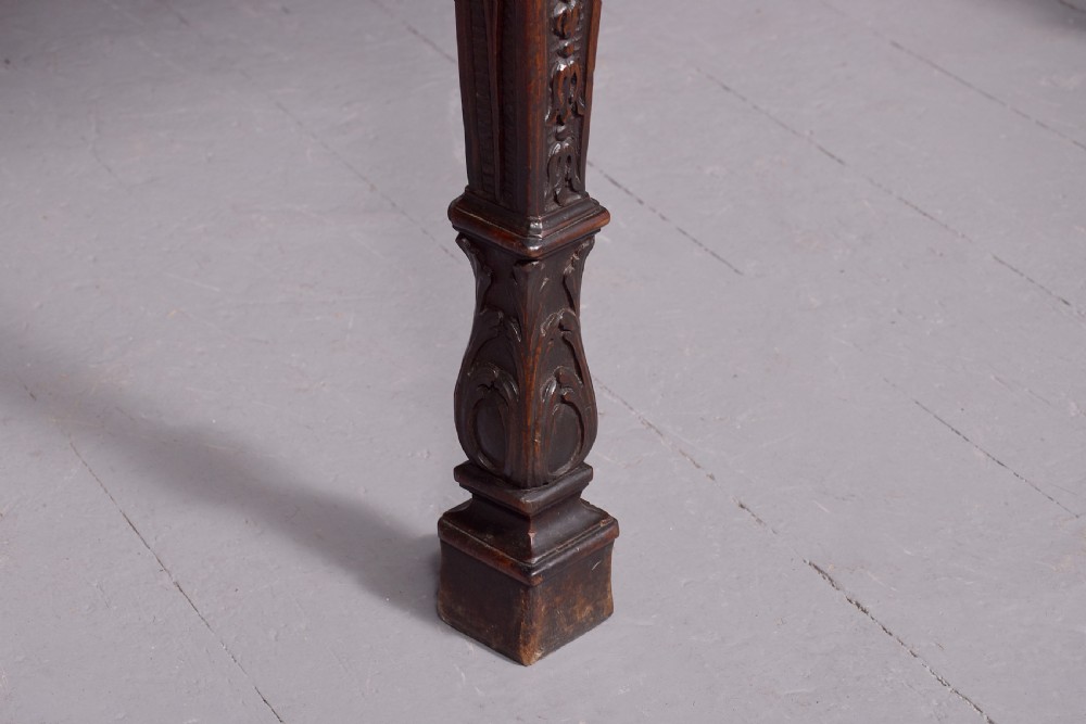 A wide George III dark mahogany serving table supported by six carved legs with intricate drapery swags running across the front frieze. View VIII