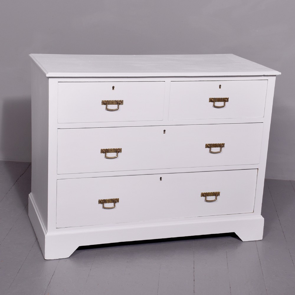 A Victorian ash chest of drawers painted in a pale Swedish grey finish, featuring a two-over-two drawer layout and brass drop handles.