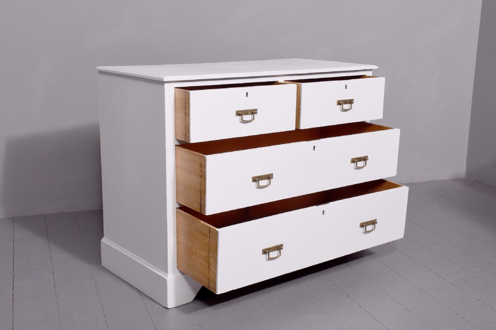A Victorian ash chest of drawers painted in a pale Swedish grey finish, featuring a two-over-two drawer layout and brass drop handles. View V