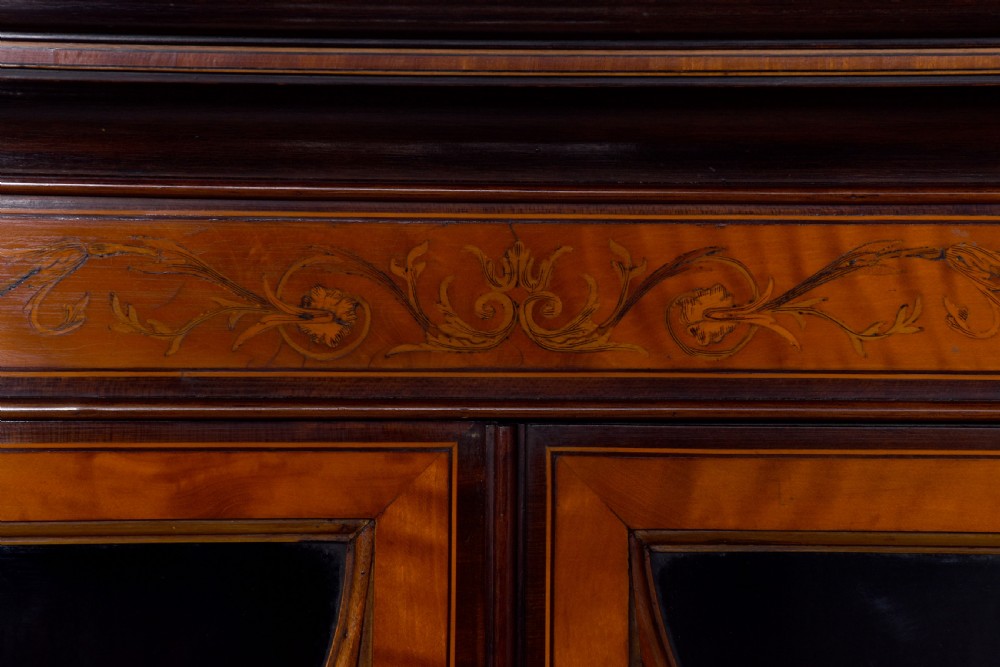 An antique satinwood secretaire bookcase featuring glazed upper doors with astragal tracery, detailed floral marquetry inlays, and an arched pediment. View II