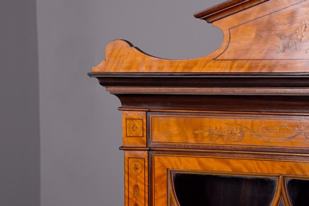 An antique satinwood secretaire bookcase featuring glazed upper doors with astragal tracery, detailed floral marquetry inlays, and an arched pediment. View III