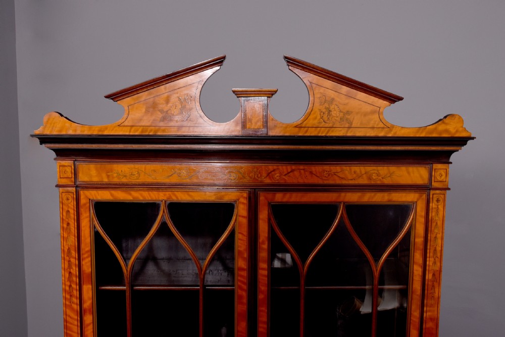 An antique satinwood secretaire bookcase featuring glazed upper doors with astragal tracery, detailed floral marquetry inlays, and an arched pediment. View V