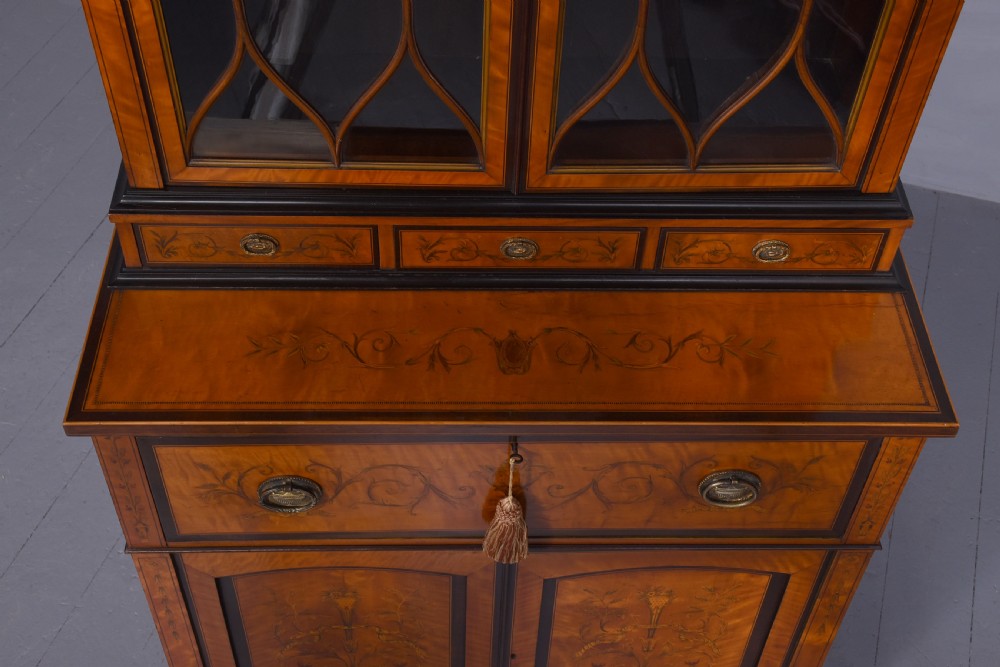 An antique satinwood secretaire bookcase featuring glazed upper doors with astragal tracery, detailed floral marquetry inlays, and an arched pediment. View XVIII